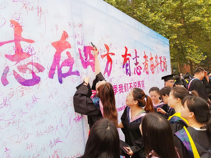 图18:毕业生在签名墙前签名